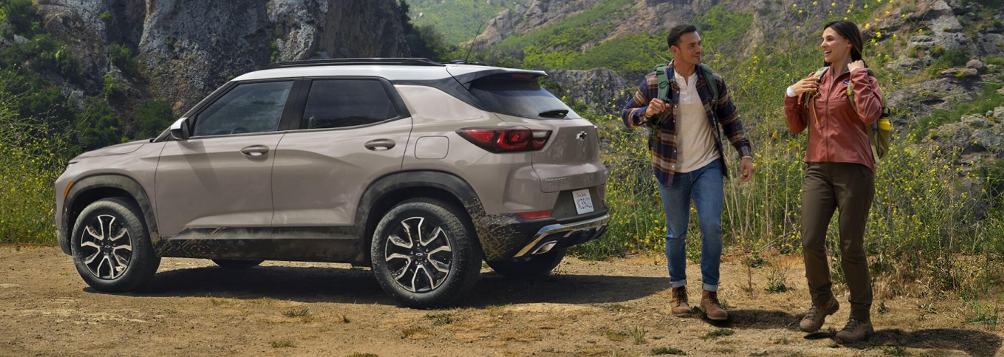 People standing around 2026 Chevrolet Trailblazer parked on grassy terrain.