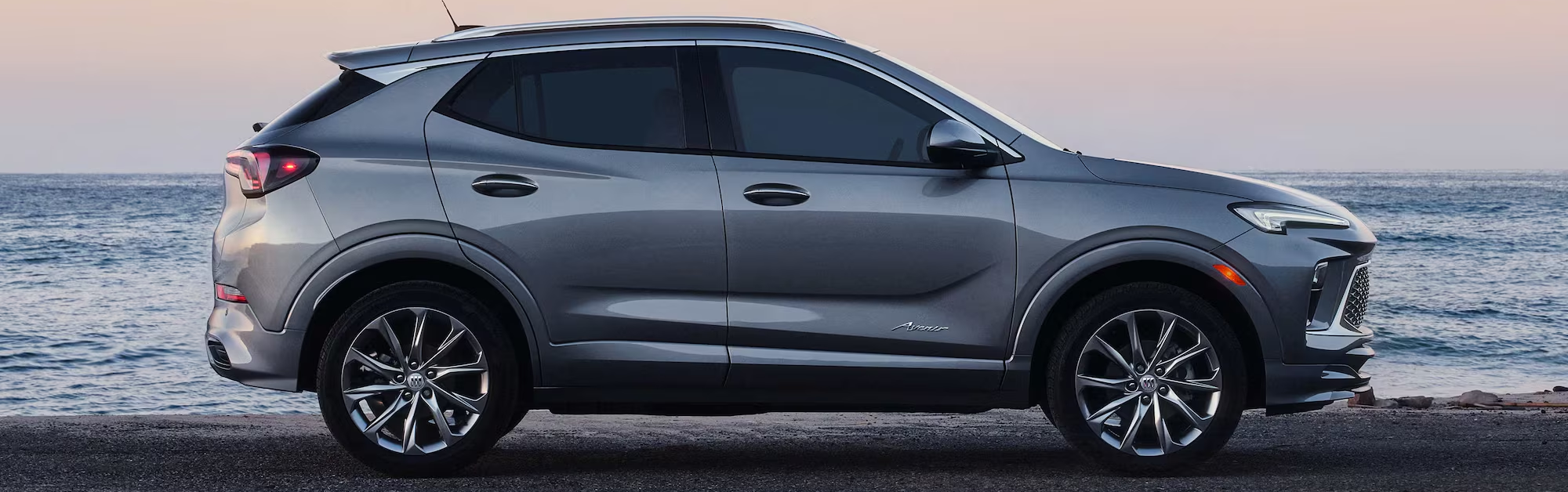 2026 Buick Encore GX parked on road with body of water in background